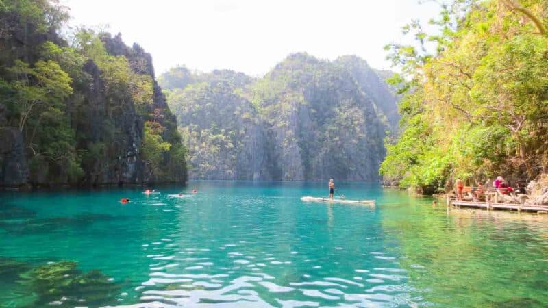 Local man paddling a bamboo raft in Kayangan Lake 