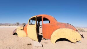 orange and yellow abandoned old classic cars in Namibia - Namib Desert - Things to do in Namibia
