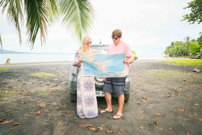 Couple holding a map on the beach in Puerto Viejo Costa Rica - couple travel tips