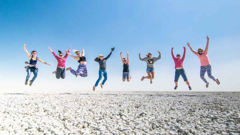 Women jumping in the Pan located in Etosha National Park - Salt Flats - must visit Namibia