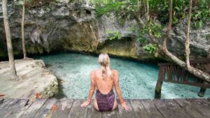 woman sitting on the deck of Gran Cenote near Tulum Mexico - One of the top cenotes in Mexico