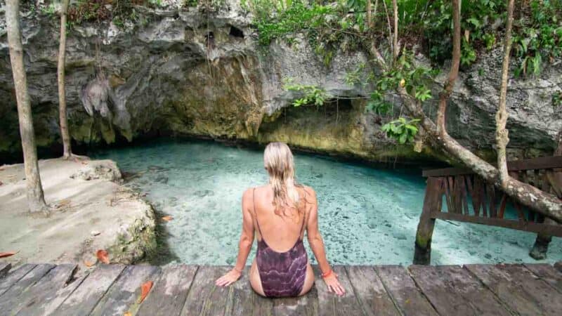 woman sitting on the deck of Gran Cenote near Tulum Mexico - One of the top cenotes in Mexico 