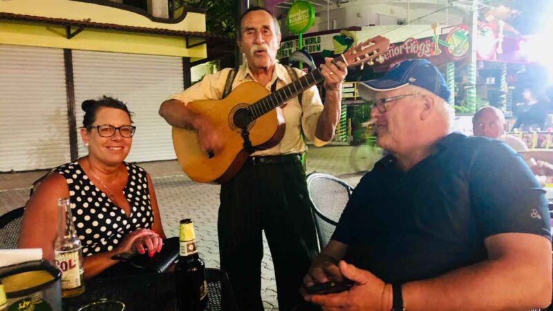 couple in Playa del Carmen and local musician on 5th Avenue. 