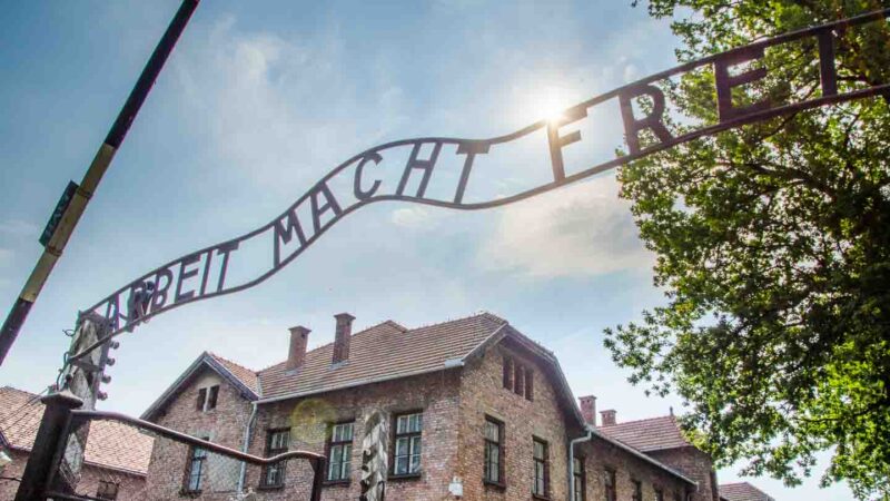 sun burst over the famous sign of Auschwitz near Krakow Must see things in Krakow Poland