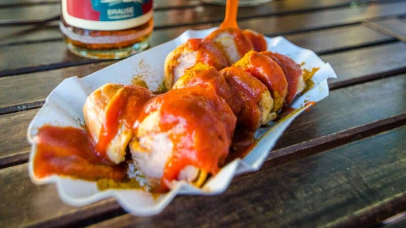 Plate of Currywurst and local drink at a restaurant in Berlin - Must eat foods with 3 days in Berlin