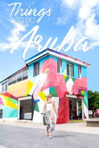 woman standing in front of Aruba's street Art - Pin for things to do in Aruba