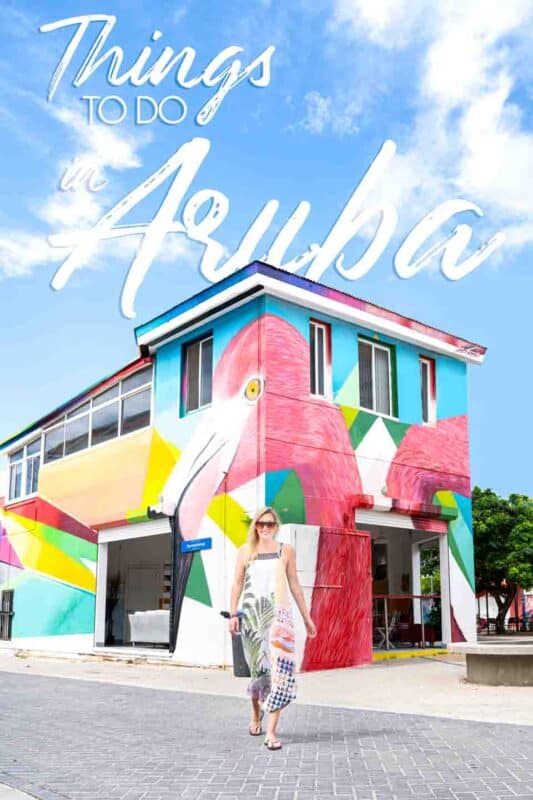 woman standing in front of Aruba's street Art - Pin for things to do in Aruba