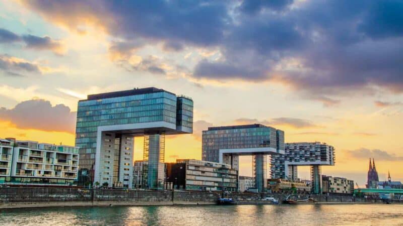 Three crane like kranhaus buildings in rheinauhafen stretch over the rhine rive in Cologne at sunset - Things to see in Koln