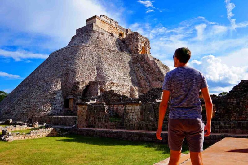 man standing in front of Uxmal Ruins in Merida Mexico