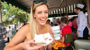 Girl having coffee & beignets at Cafe du Monde in New Orleans
