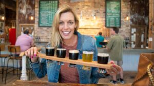 Woman holding beer sample paddle at Door County Brewing - Places to eat in Door County