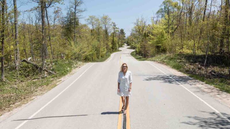 Must see things in door county long weekend - Woman standing on the windiest road in Wisconsin
