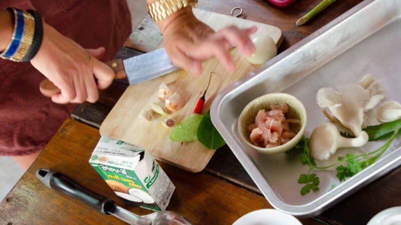 woman cooking during a Chiang Mai Cooking Class learning to cook Thai dishes - tiop things to do in Chiang Mai