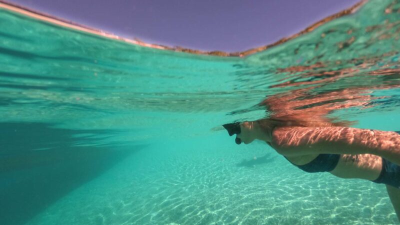 woman snorkeling in the turquoise waters of Rarotonga - Top activities