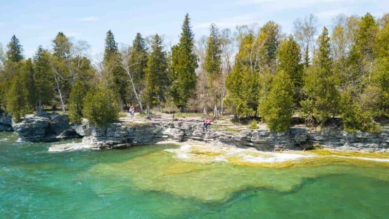 Couple sitting on the bluffs of Cave Point County Park in door Count - Must visit