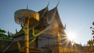 The famous Wat Doi suthep in Chiang Mai at sunrise with a starburst with golden umberalls