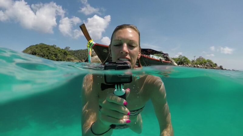 woman holding a GoPro under water in Thailand - GoPro Tips for Beginners
