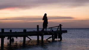 Girl on a dock watching the sunset in Aruba