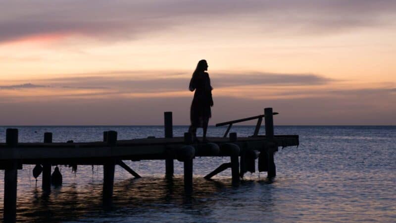 Girl on a dock watching the sunset in Aruba