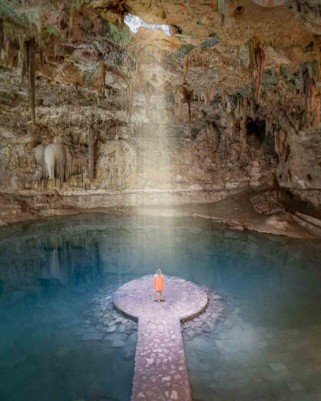 woman standing in a sunbeam inside Cenote Suytun near Valladolid mexico