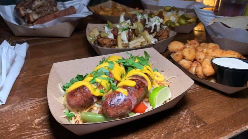 sausages with Thai toppings along side cheese curds served at Vanguard restaurant in Bay View - One of City's Best