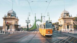 Yellow Tram crossing the liberty bridge in front of Great Market Hall in Budapest