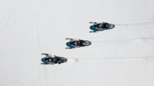 Drone photo of three snowmobiles in fresh snow near the Black Hills in South Dakota