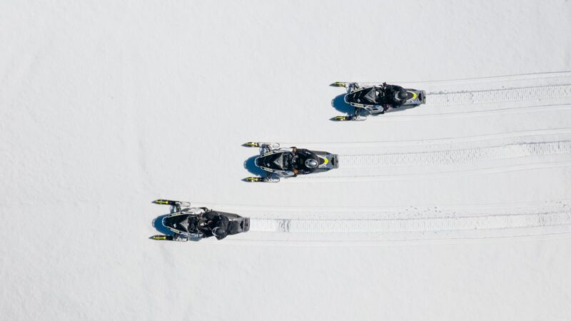 Drone photo of three snowmobiles in fresh snow near the Black Hills in South Dakota
