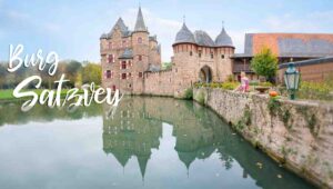Reflection in the moat of Burg Satzvey Castle in Germany - woman sitting on brick entrance to the castle for the featured image