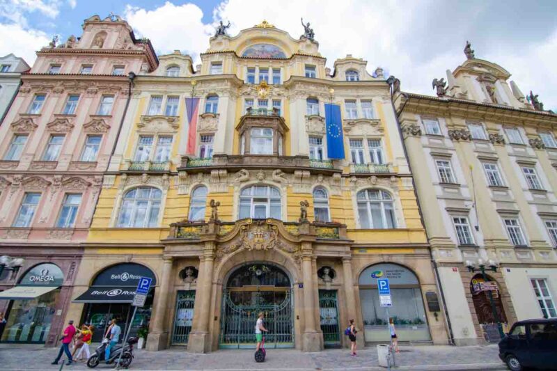 Edificio amarillo con banderas cerca de la calle París en el barrio judío de Praga