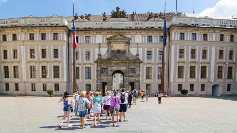 Grupo de turistas entrando al castillo de Praga en una visita guiada al castillo. 