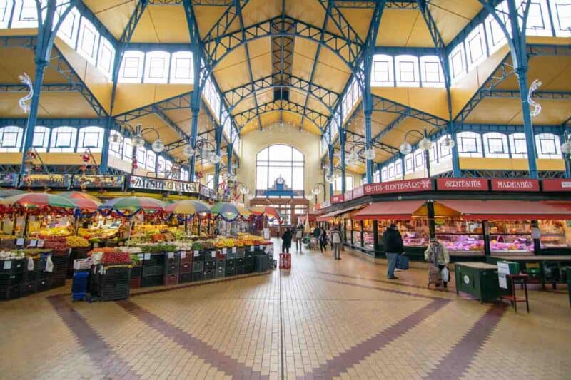 Fruit display infront of the large window filled walls inside the great market hall in Budapest