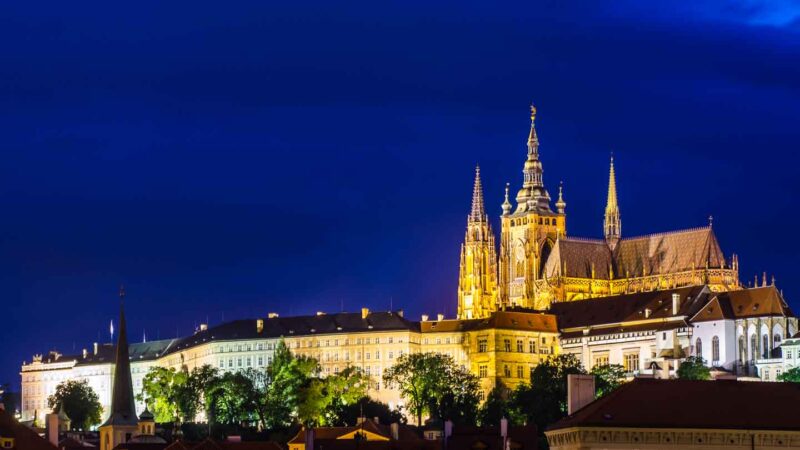 Horario de apertura del Castillo de Praga - Foto nocturna del Castillo de Praga con cielo azul profundo y castillo amarillo y agujas