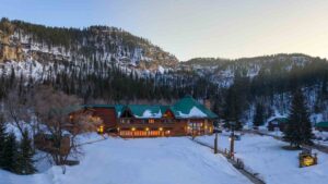 Drone photo of the Spearfish Canyon Lodge surrounded by snow at sunset during a Black Hills Snowmobiling Trip
