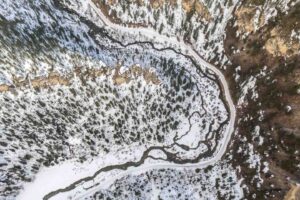 High Aerial Photo of the snowmobile trails in the Black Hills, SD - snow and river bending around rock formations