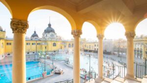 sunburst coming through the yellow archway of the Szechenyi Thermal Baths - Famous Budapest Baths