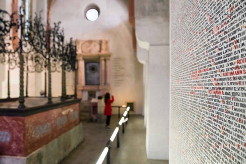 Handwritten names from the Holocaust on the walls of the Pinkas Synagogue in black and red