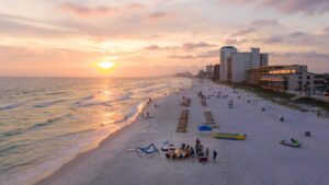 group of people gathered around a beach bonfire in Panama city beach during sunset - List of things to do