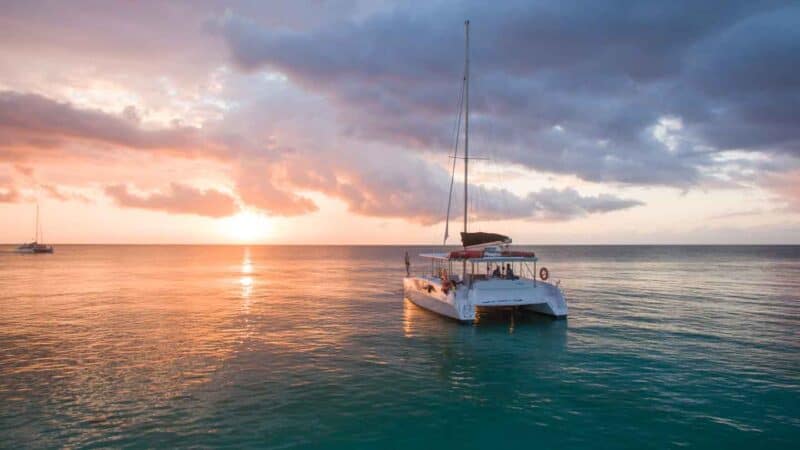 crucero en catamarán al atardecer- mujer parada en proa - Cosas que hacer en Cozumel