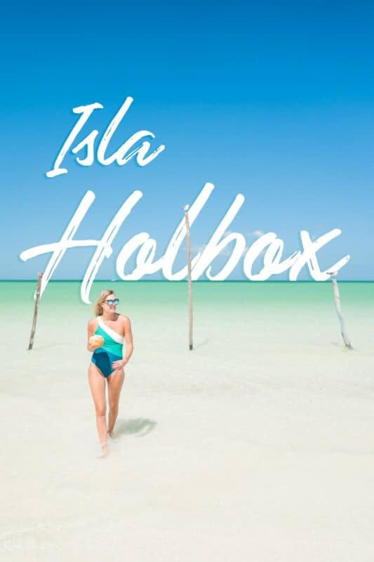 woman standing in front of wooden posts in the waters of Isla Holbox - Pinterest pin for Isla Holbox Travel Guide