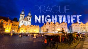 Featured image for Prague Nightlife - Prague cityscape at night with famous church in front of a blue sky