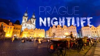 Featured image for Prague Nightlife - Prague cityscape at night with famous church in front of a blue sky