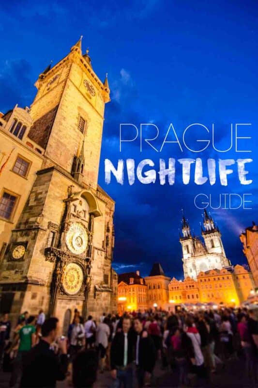 Crowd gathered in front of the popular Prague clock tower at night - Pinterest pin for Prague Night Life - Bar, club and nightlife guide