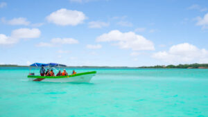 group of people on a day boat trip in Laguna Bacalar mexico - boat in aqua colored water with several passengers
