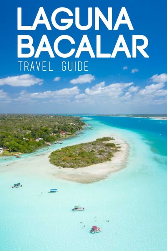 Drone photo of the teal and blue waters of Laguna Bacalar with shoreline and small island in view