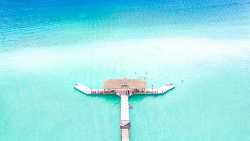 Drone photo of Bacalar Mexico with long pier and hut at the end - Places to visit in Mexico