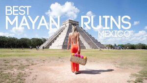woman in an orange dress standing in front of Chichén Itzá - Best mayan Ruins in Mexico