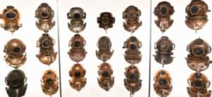 vintage diving helmets in front of a white back ground - History of Diving Museum