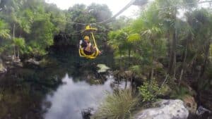 woman on a yellow cable bike at Xel Ha Park near Cancun Mexico - Things to do in Cancun