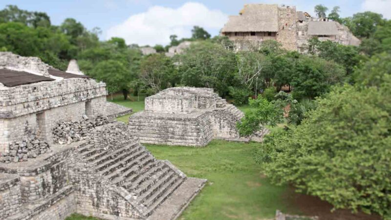 Mayan Site of Ek Balam - Stone structures with green grass and trees surrounding - Best Mayan Ruins in Mexico 